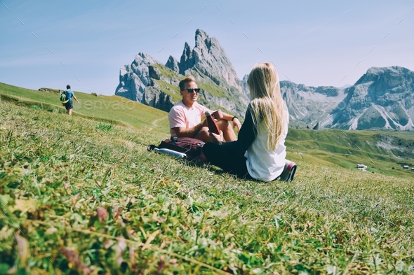 Hiking couple taking a break in front of mountain range - Stock Photo - Images