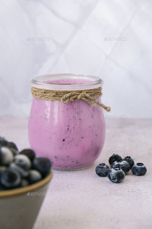 Blueberry smoothie topped with blueberries. A glass of breakfast protein smoothie drink made from