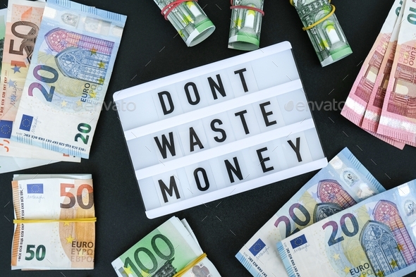 Lightbox board with word DONT WASTE MONEY in black letters around euro banknotes. Money, Business, f