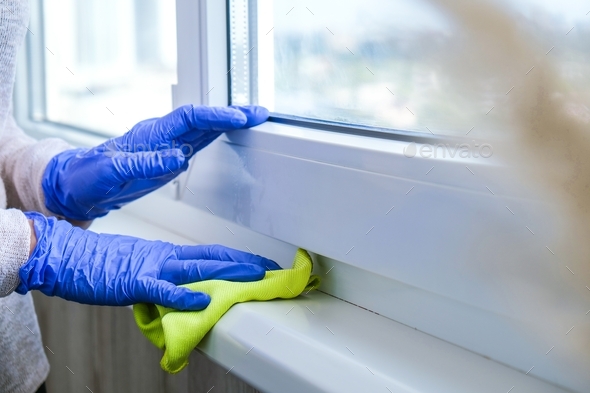 Cleaning the windowsill wiping dust by blue microfiber cloth for ...