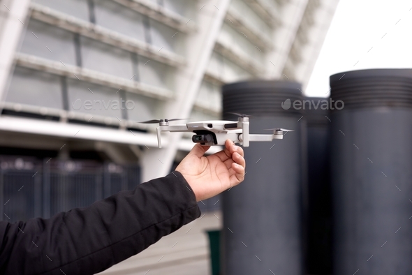 man hand hold drone before launch in city street. exploring new building with innovative technology - Stock Photo - Images