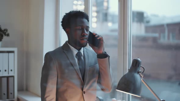 Young Black Businessman Having Phone Conversation in Modern Office alt