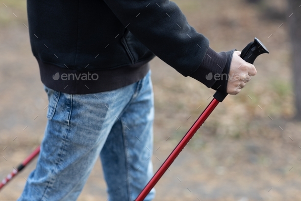 Young man walks with Scandinavian walking sticks. Healthy lifestyle