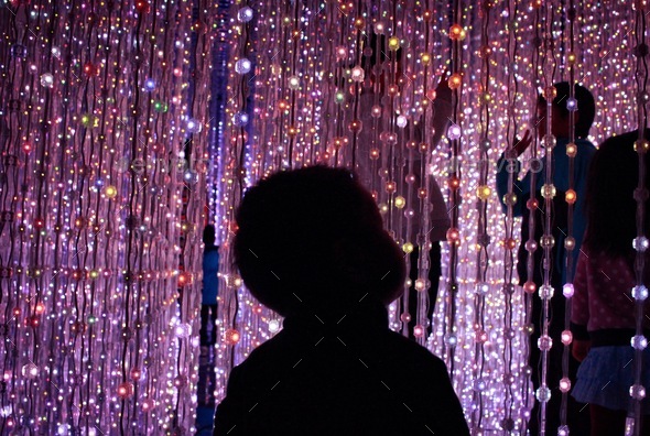 Toddler amused by the led lights display  - Stock Photo - Images