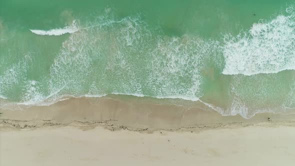 Sea with Rolling Waves and Sandy Beach Aerial Vertical Top Down View alt