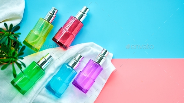 Flat Lay of cosmetic spray bottles on pink and sky blue background