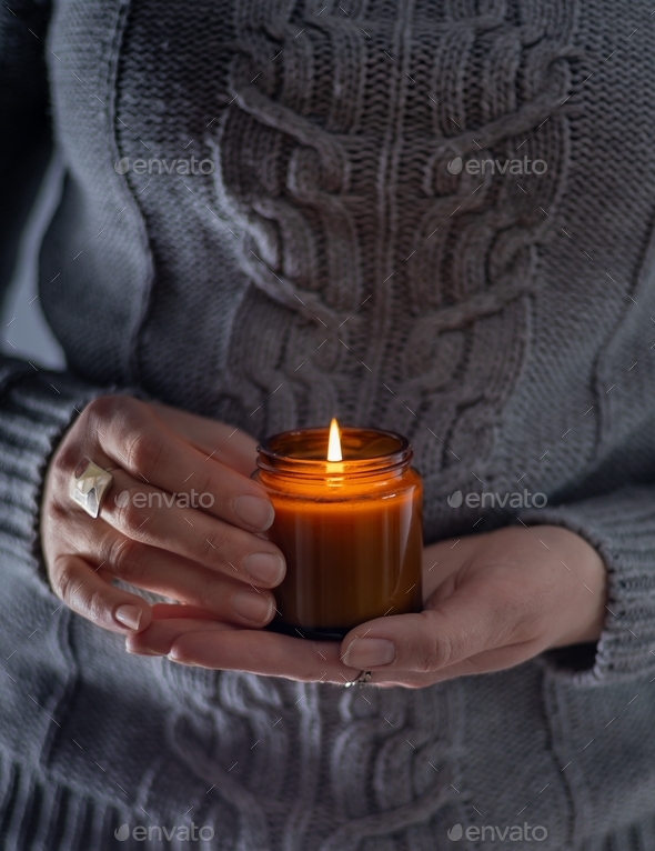 Light and hold a soy candle in your hands. Candle in a jar