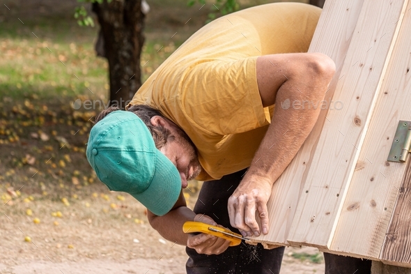 Father working on wells roof in homestead  - Stock Photo - Images