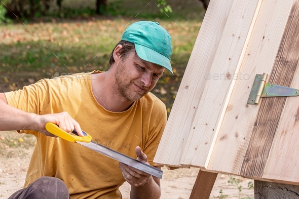 Father constructing wells roof in homestead  - Stock Photo - Images