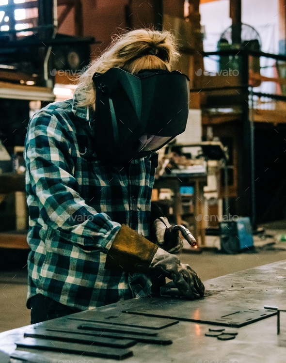 A female welder welding in a metal shop