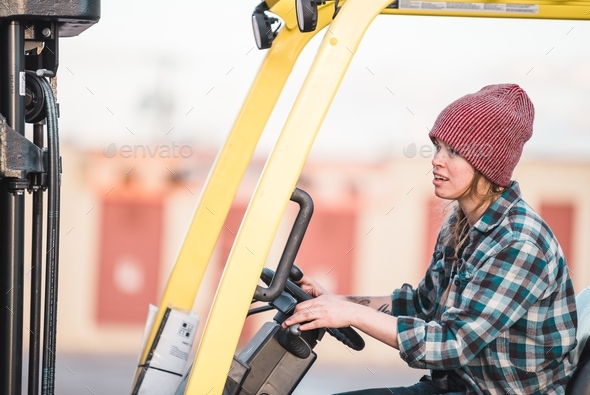 A woman operates a forklift at a job site