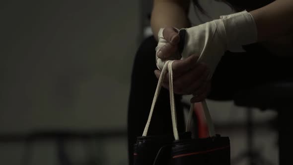 Woman at the boxing club sitting and holding gloves