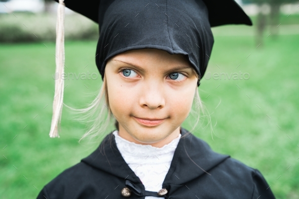 Back to elementary school concept. Little girl goes to first grade. Ceremony of graduating. Black go