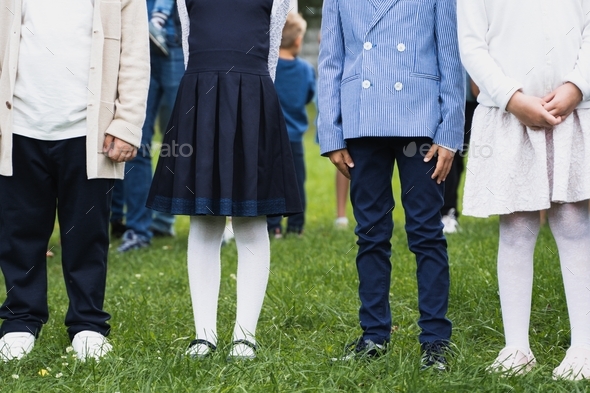 Back to elementary school concept. Children hold hands, go to first grade. Ceremony of graduating. W