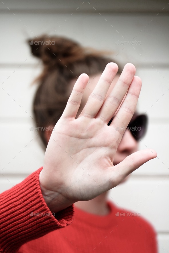 Girl holding her hand over her face. Hand gestures meaning no pictures filming, respecting privacy. - Stock Photo - Images