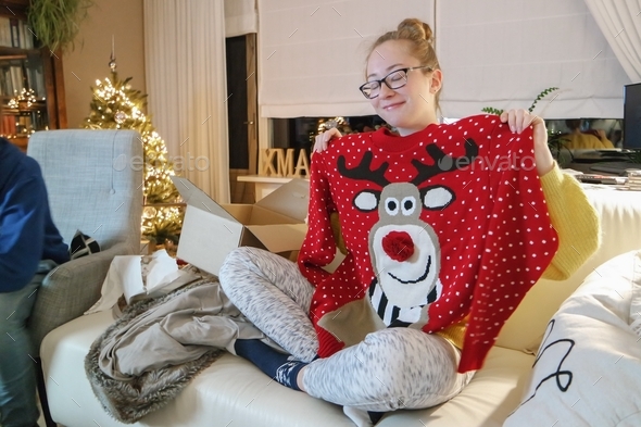Girl getting presents for Christmas. Very happy with her ugly sweater.