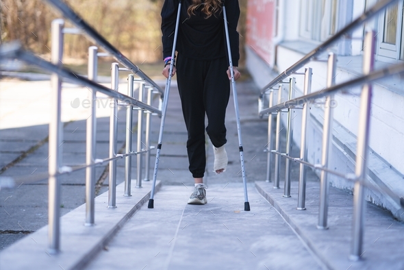 Young woman with a broken ankle on crutches.