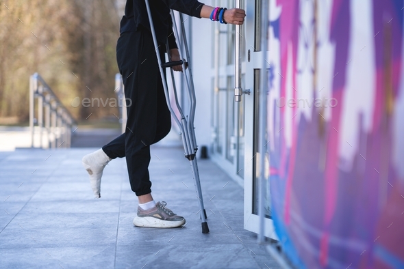 Young woman with a broken ankle on crutches.