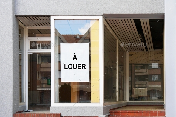 french vacancy sign in shop or store window reads a louer which translates as for rent