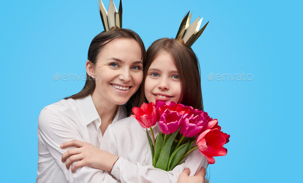 Cheerful mother and girl with 8 March bouquet