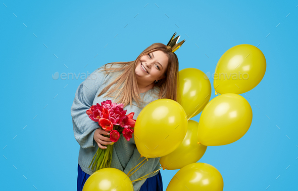Cheerful plus size female with flowers and balloons