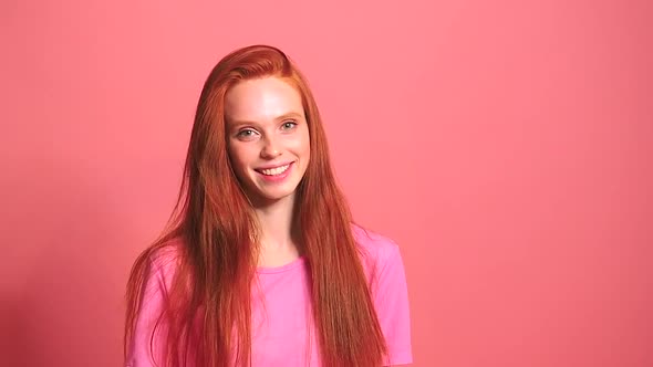 Redhaired Ginger Woman in Pink Studio Background Smile and Feeling Good alt