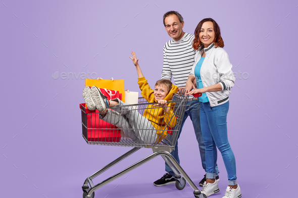 Happy family with shopping cart and purchases