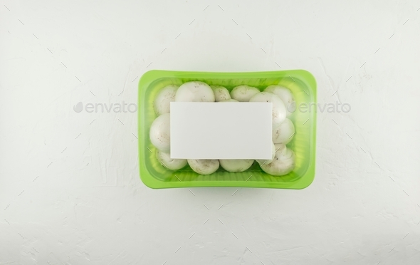 farm mushrooms champignons in plastic packaging on a white background. top view. logo layout design.
