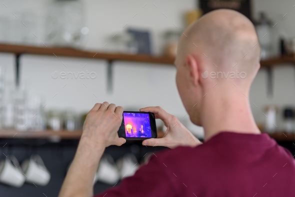 Person doing thermal scanning of apartment - Stock Photo - Images