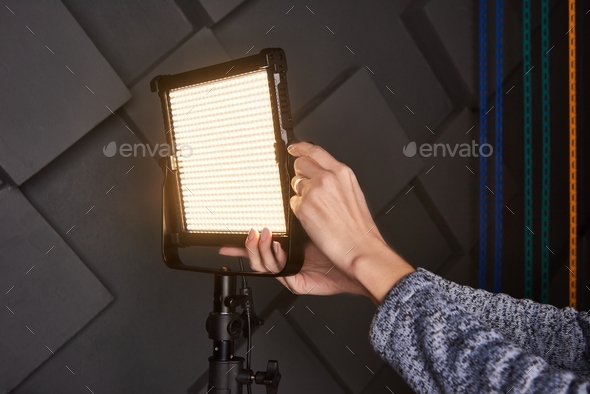 studio assistant fix professional video light on adjustable light stand. Led lamp on tripod