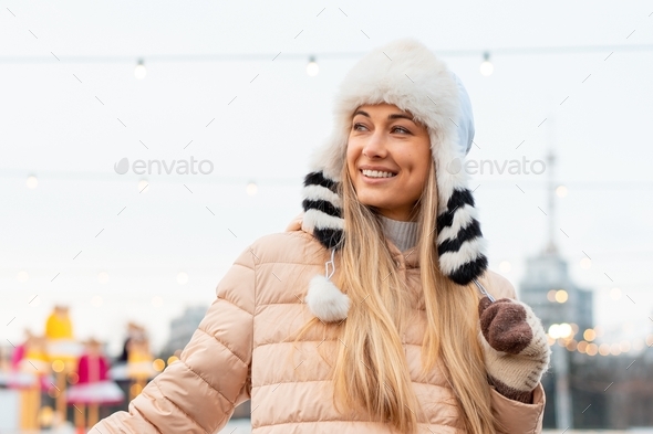 Woman in fluffy fur hat winter jacket standing outdoor Christmas mood