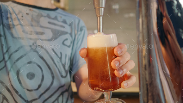 Detail of a Unrecognizable filling a glass of beer in a bar