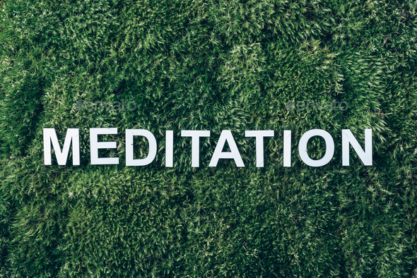 Word Meditation on moss, green grass background. Peace of Mind, health concept