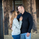 A couple dressed in sweaters standing under a pier romantically looking into each other eyes.  - PhotoDune Item for Sale
