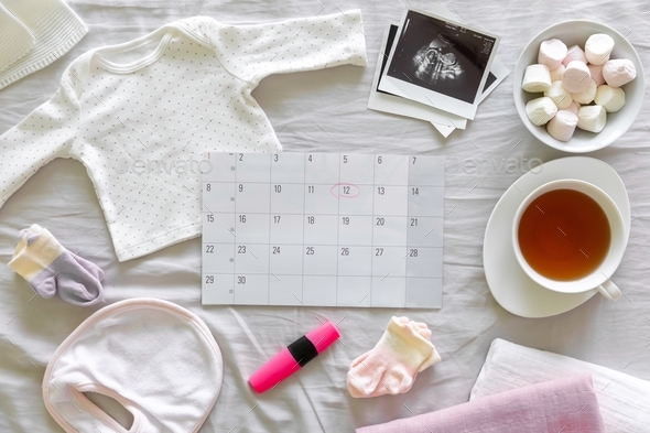 Calendar with the expected date of birth of the baby, different baby clothes and ultrasound scan