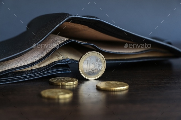 Few euro coins lies by wallet