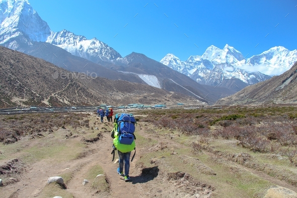 Sherpa porter carries backpacks in Himalayas - Stock Photo - Images