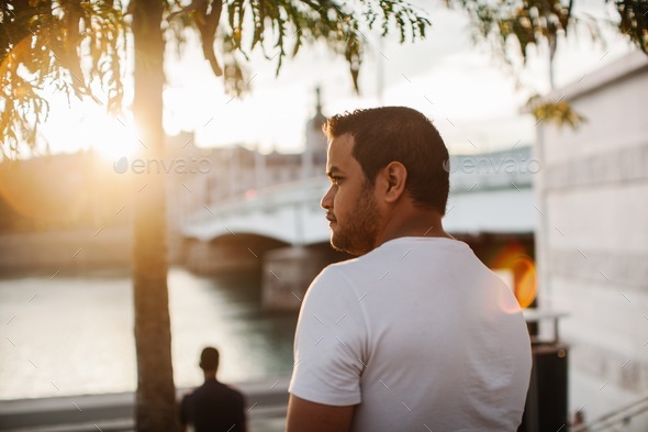 Portrait of a man from behind walking in the city of Lyon during sunset