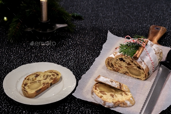 Traditional Christmas stollen with dried fruits, raisins and marzipan decorated with sugar powder - Stock Photo - Images