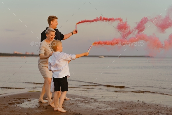 Family having gender reveal announcement using pink smoke waiting for baby girl
