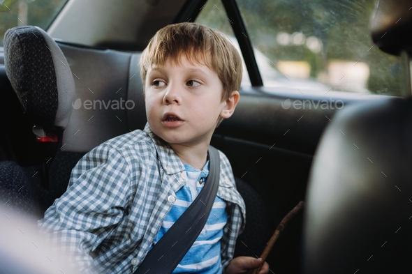 Cute caucasian boy travelling by car sitting in child seat. Family ...