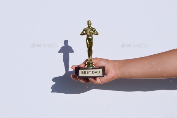 NOMINATED Holding a BEST DAD award and trophy on a white background with cool shadow