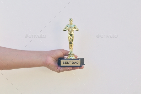 Holding a BEST DAD award and trophy on a white background with cool shadow