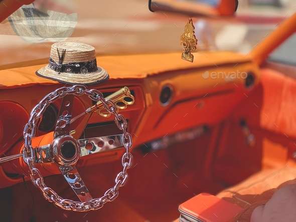 Custom low rider with silver chain steering wheel and orange interior ready for street cruising