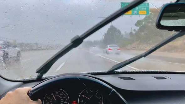 Driving in the car in the rain with the windshield wipers