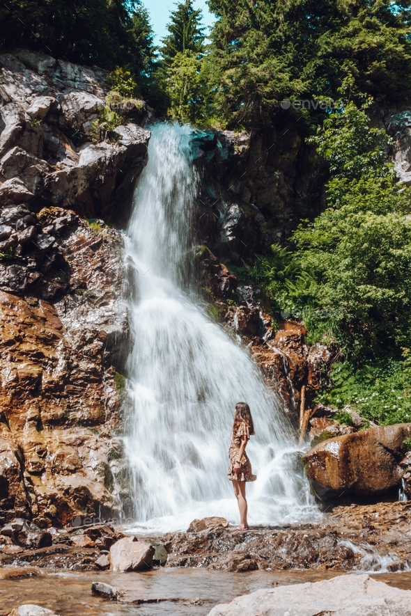 Woman enjoying the waterfall's breeze - Stock Photo - Images