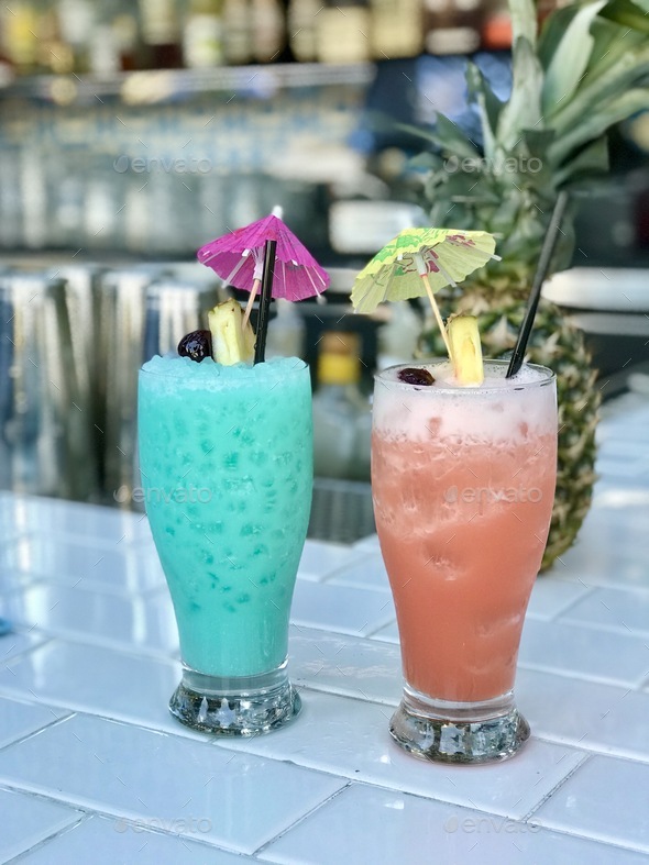 Colorful tropical alcoholic drinks cocktails with pineapple garnish and ...