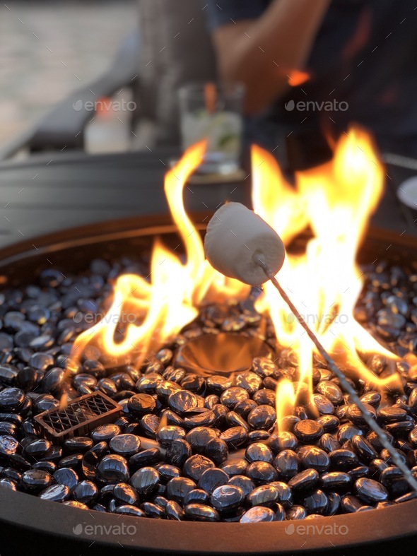Backyard living, roasting marshmallows over an open fire on a warm summer night