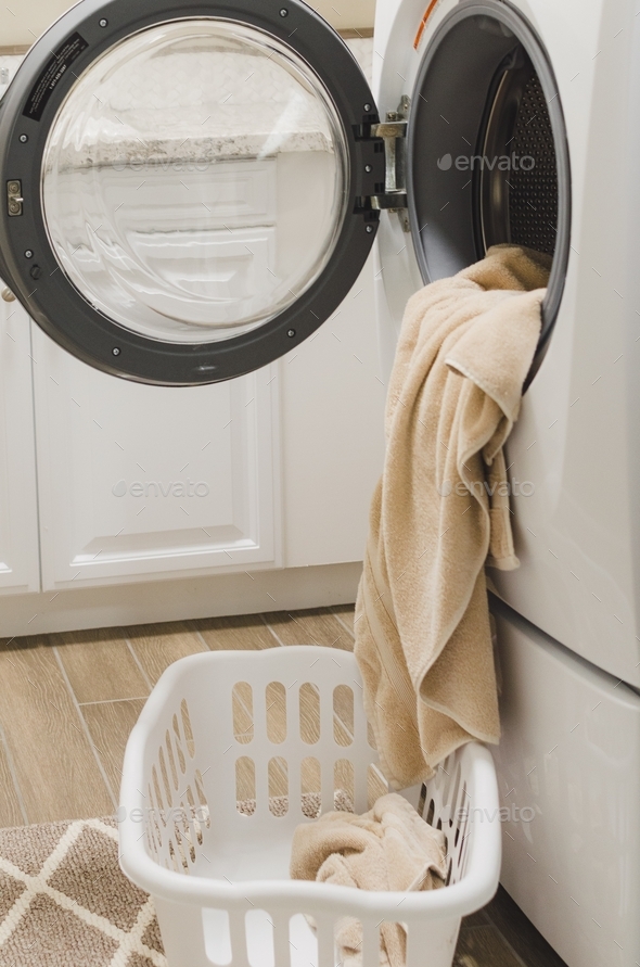 Towels coming out of or going into the washer or dryer in the laundry