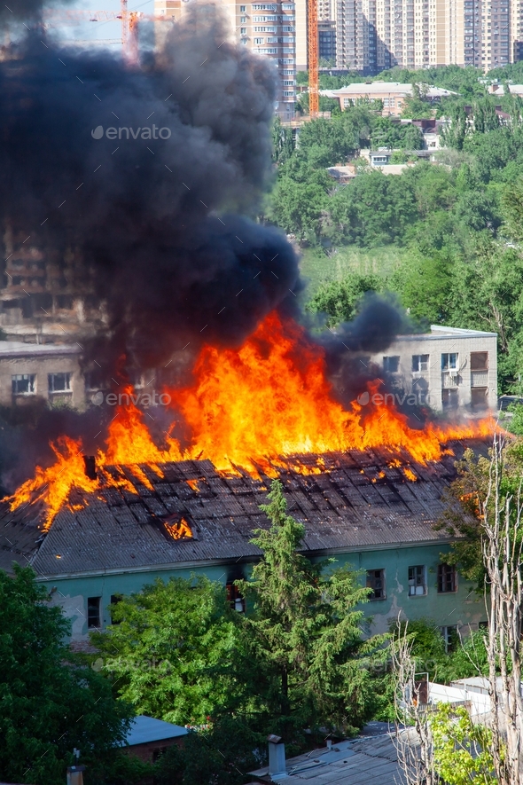 A fire in an old abandoned house, a view from the window of a neighboring high-rise building.